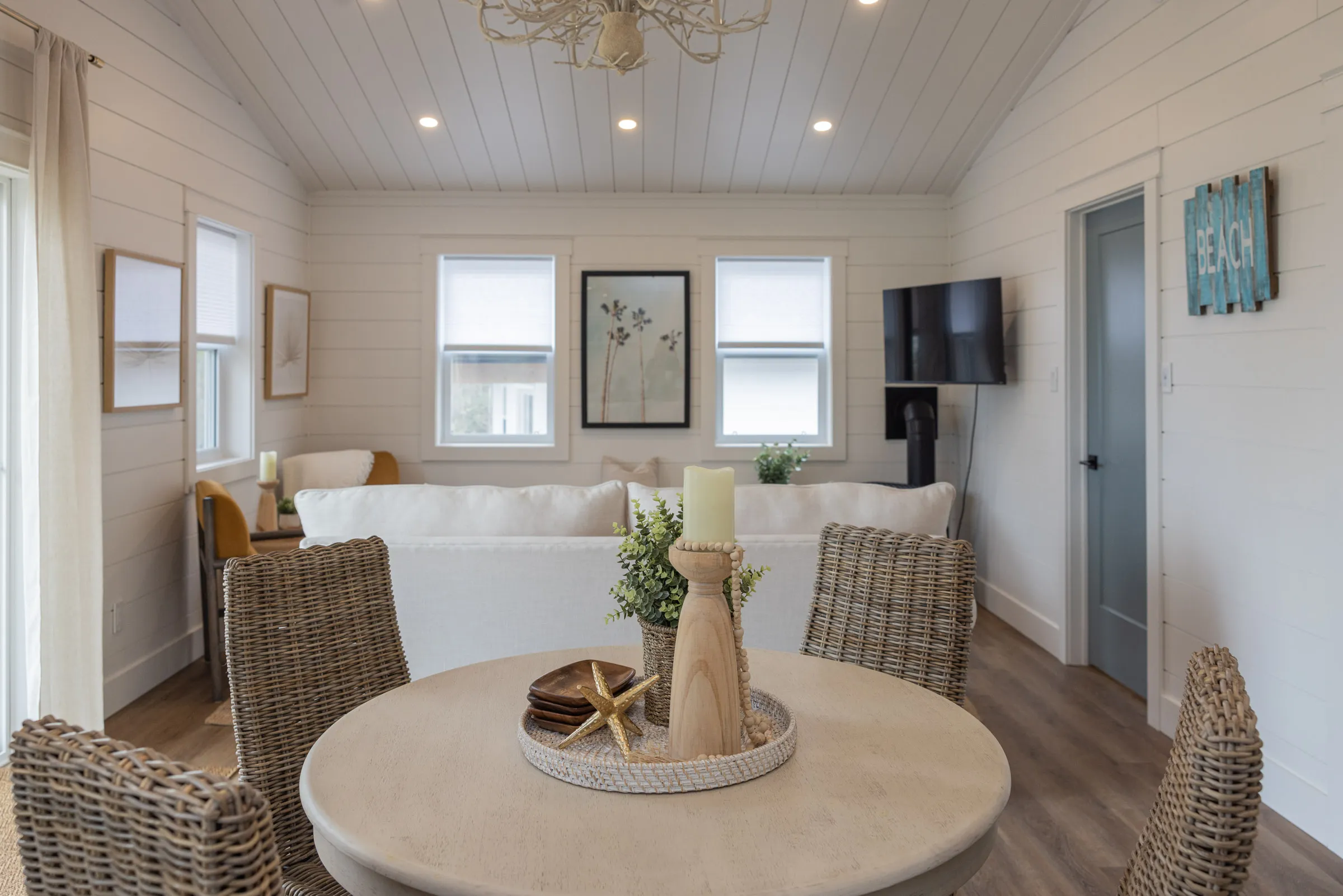 The Beach living and dining area with a sofa, armchairs and round table.