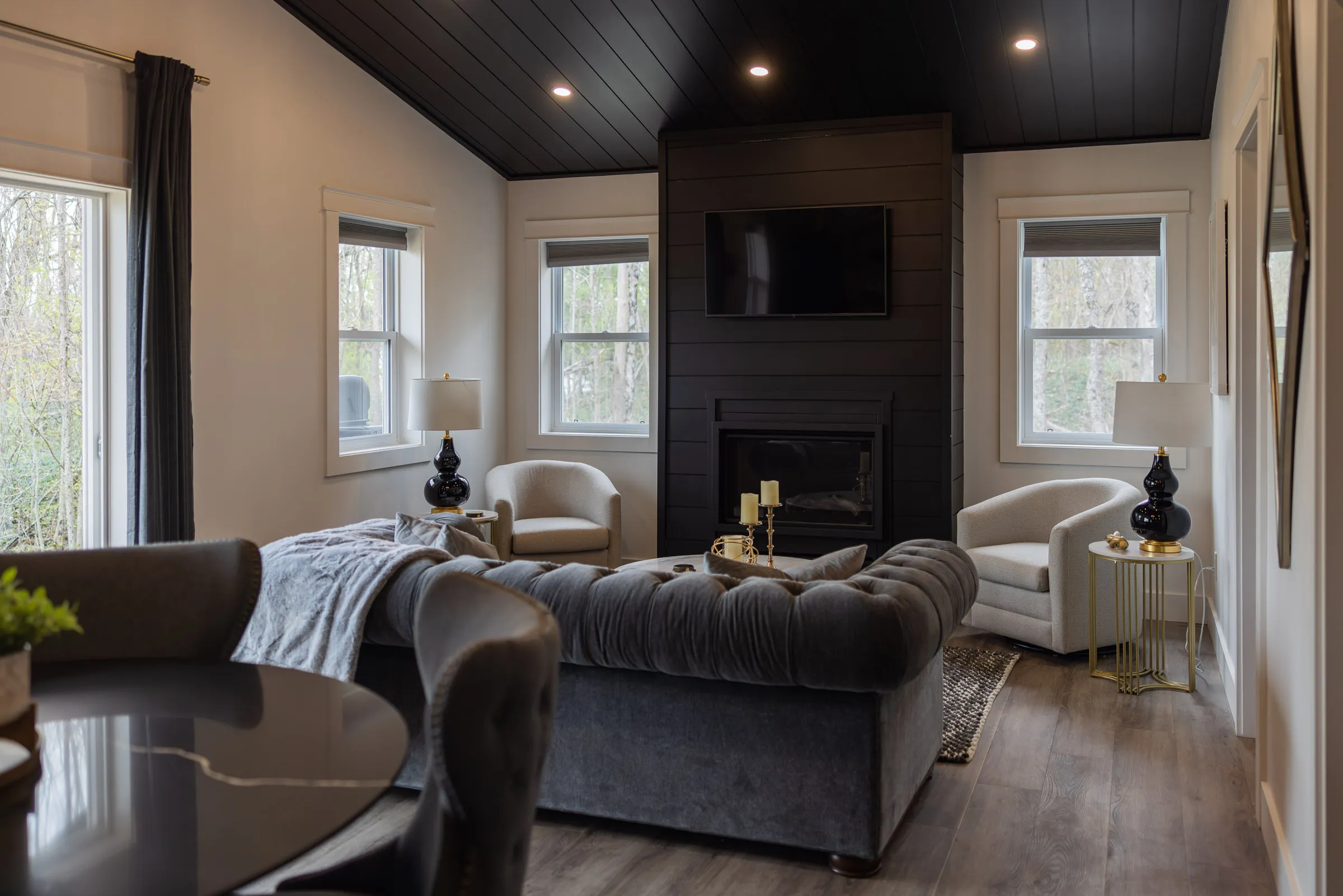 The Vintage Hollywood lounge with a grey sofa, cream chairs and fireplace.