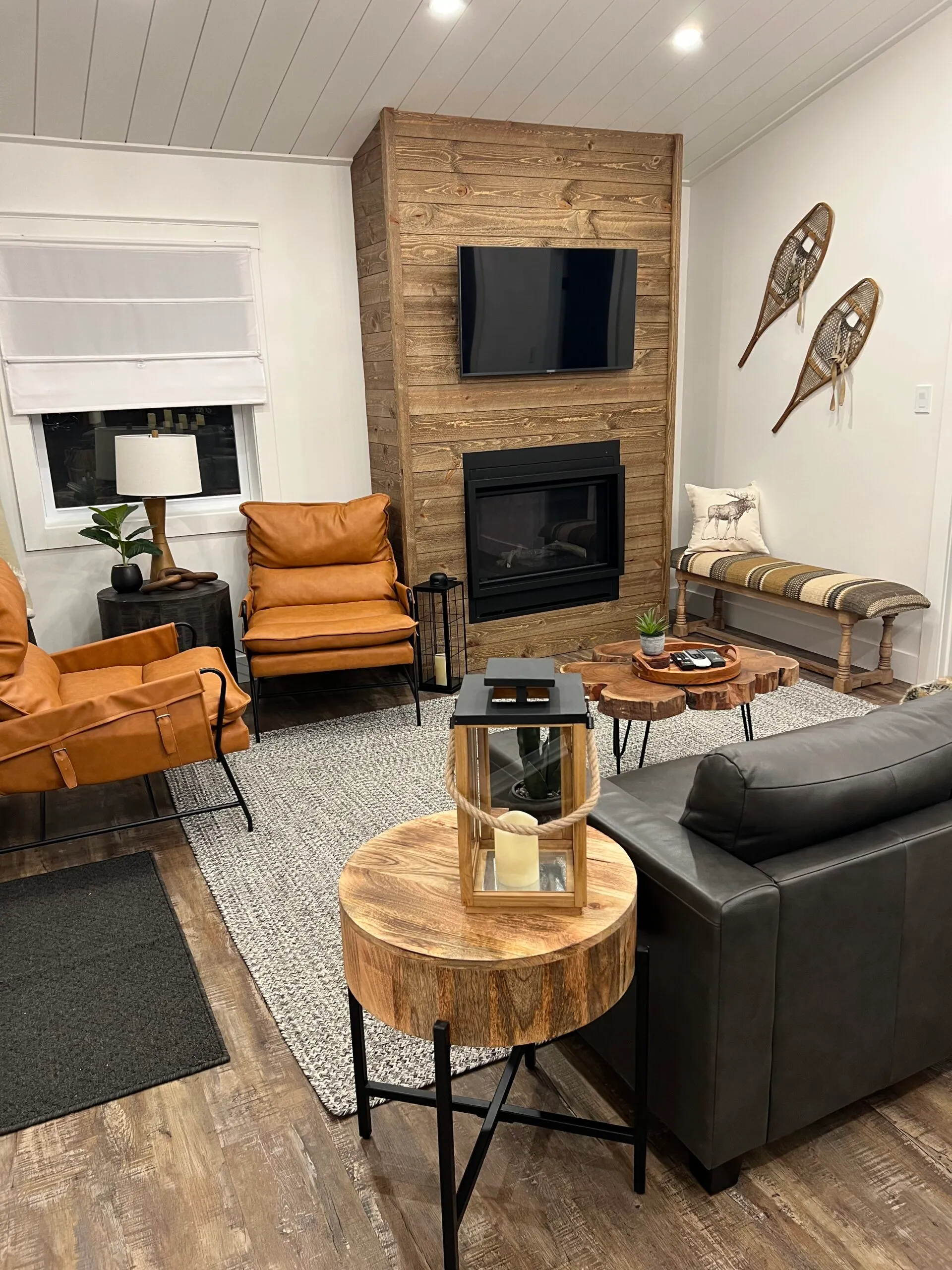 The Rustic Lodge sofa and leather chairs facing a wood-clad fireplace.
